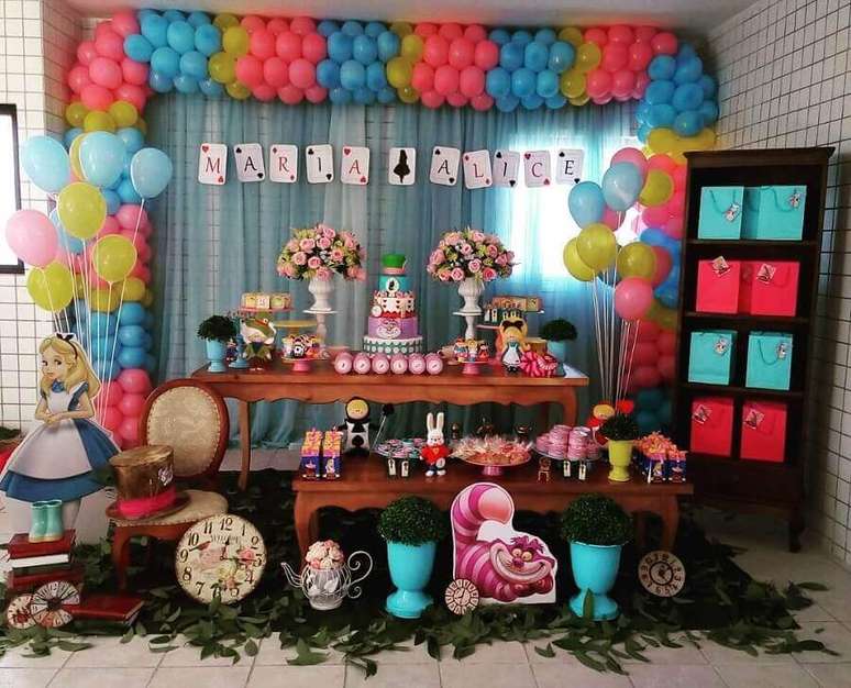 6. Balões coloridos e folhas embaixo da mesa para decoração de festa Alice no País das Maravilhas simples – Foto: Pinterest