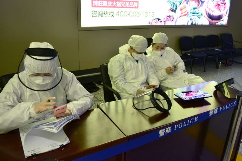 Funcionários com trajes de proteção em posto de controle em aeroporto de Harbin, na China
11/04/2020 REUTERS/Huizhong Wu