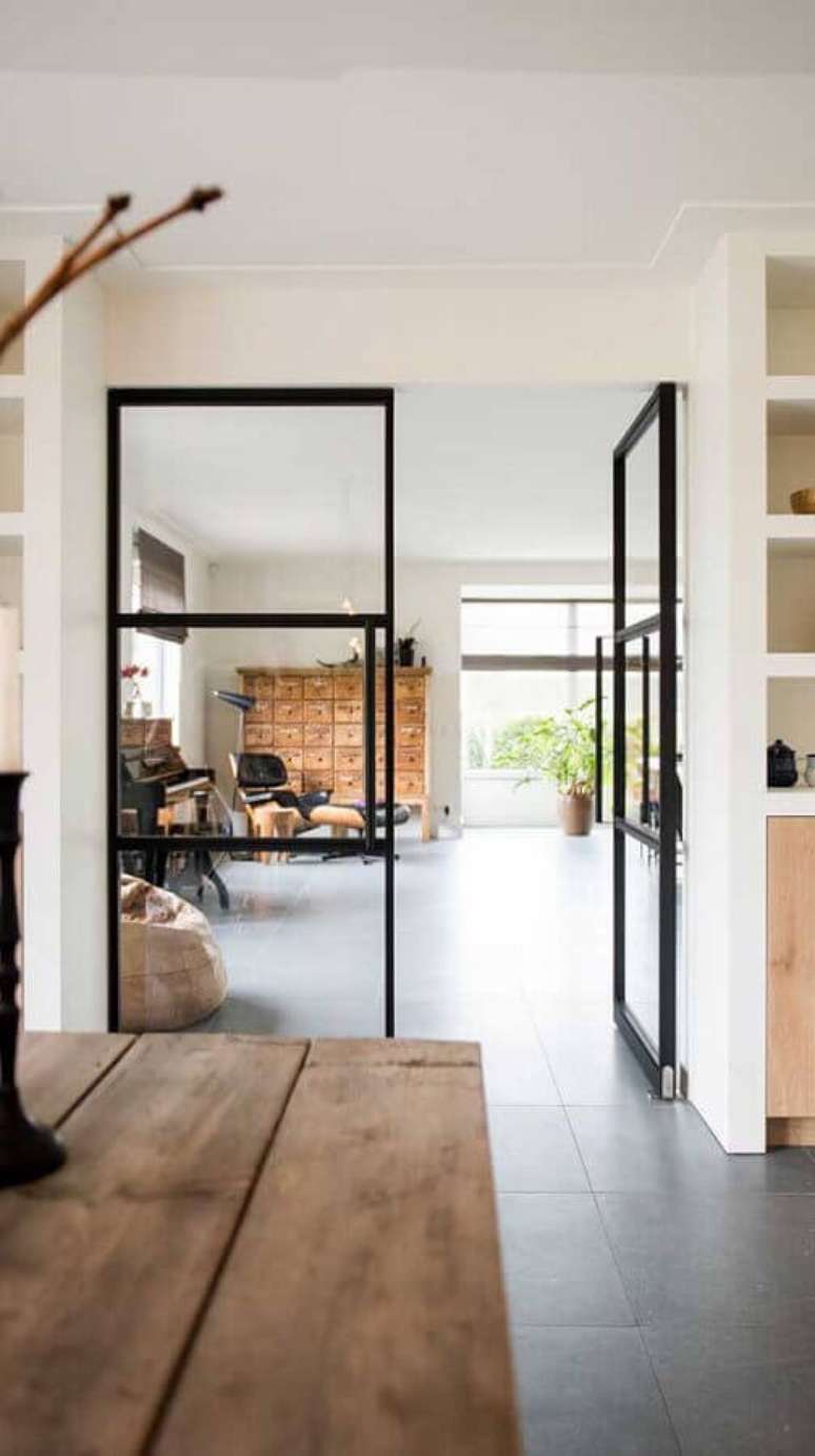 27. Decoração minimalista com porta francesa de vidro com estrutura preta – Foto: Archello