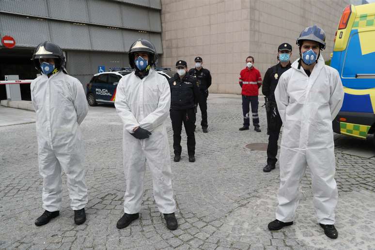 Bombeiros e policiais com trajes de proteção fazem um minuto de silêncio em Segovia, na Espanha
23/04/2020 REUTERS/Susana Vera
