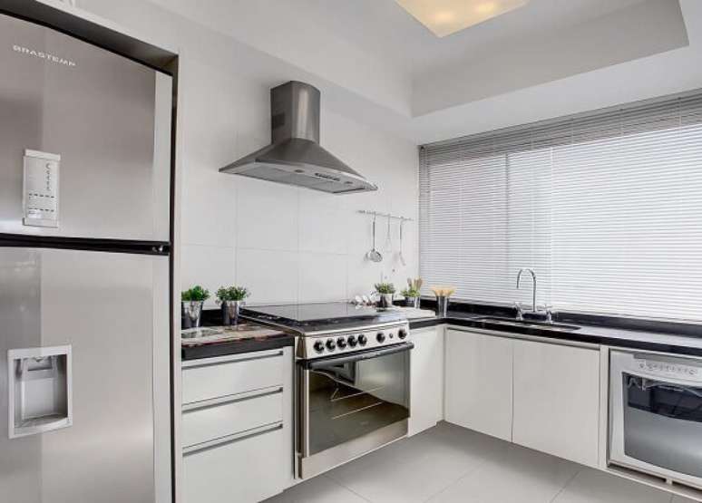 2. O fogão de inox se encaixou perfeitamente nos móveis planejados da cozinha. Projeto por Sesso & Dalanezi Arquitetura+Design