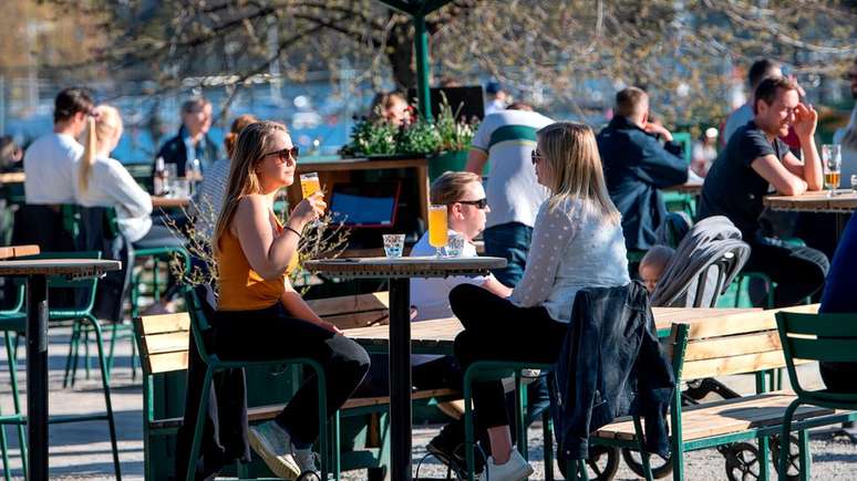 A maioria dos suecos está fazendo um distanciamento social voluntário, mas o clima ensolarado trouxe as pessoas de volta às ruas