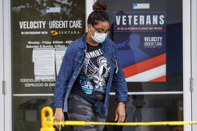 Uma mulher de máscara deixando uma clínica na Virgínia, nos Estados Unidos