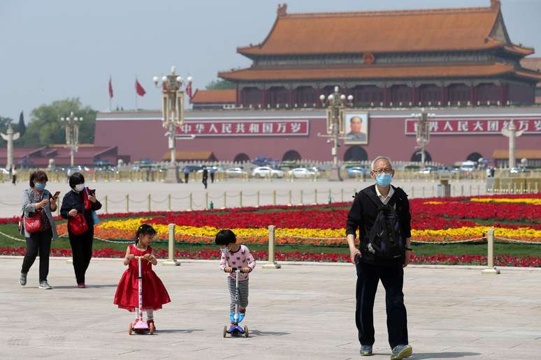 Pessoas usando m&aacute;scaras de prote&ccedil;&atilde;o caminham na Pra&ccedil;a da Paz Celestial em Pequim
29/04/2020 China Daily via REUTERS 