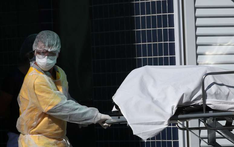 Profissional de saúde com roupa de proteção remove corpo para caminhão refrigerado em hospital do Rio de Janeiro
28/04/2020
REUTERS/Ricardo Moraes