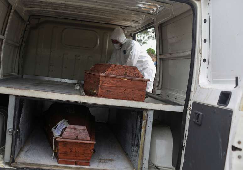 Agente funerário retira caixões de veículo para enterros em cemitério de Manaus
28/04/2020
REUTERS/Bruno Kelly