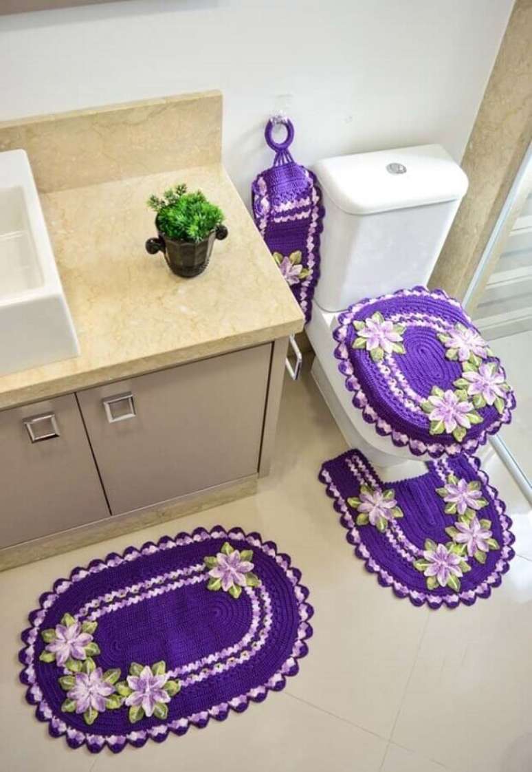 26. Decora&ccedil;&atilde;o com jogo de banheiro de croch&ecirc; com flores roxas e lil&aacute;s &ndash; Foto: Lia&rsquo;s Crochet