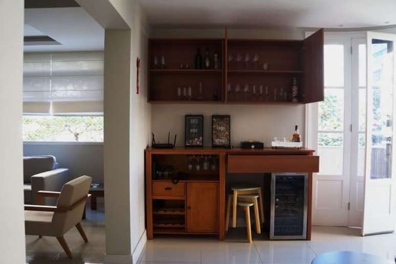 24. Os m&oacute;veis de madeira ajudam na organiza&ccedil;&atilde;o dos utens&iacute;lios do home bar. Projeto por Ana Ozenda Arquitetura + Interiores