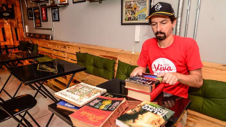 Guto Lima, dono do Tralharia, organiza livros; apesar de o horizonte em termos financeiros n&atilde;o ser animador, ele diz ter 'convicc&ccedil;&atilde;o' de estar 'tomando o caminho certo' mantendo neg&oacute;cio fechado