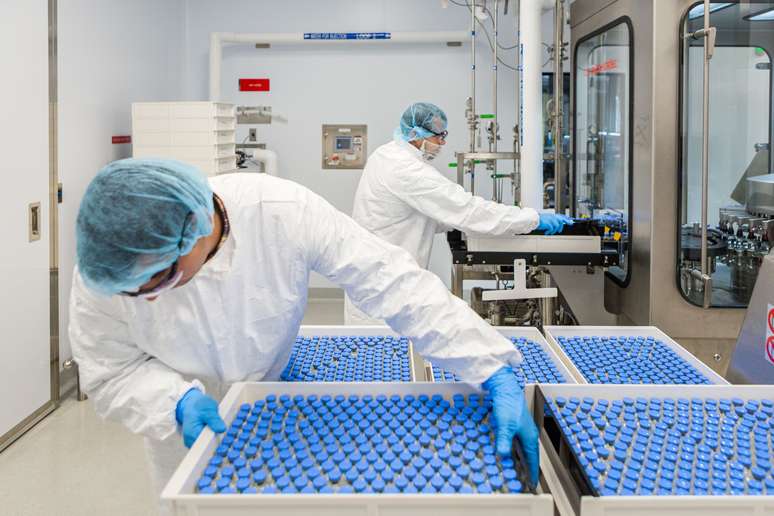 Técnicos de laboratório carregam frascos cheios de remdesivir experimental em uma instalação da Gilead Sciences em La Verne