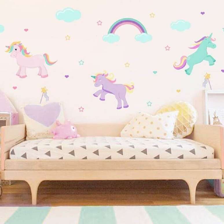40. Papel de parede para quarto de menina unicórnio com cama de madeira – Foto: Pinterest