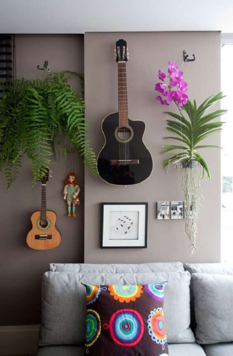 13. Plantas pendentes para decoração moderna de sala cinza com violão na parede – Foto: Histórias de Casa