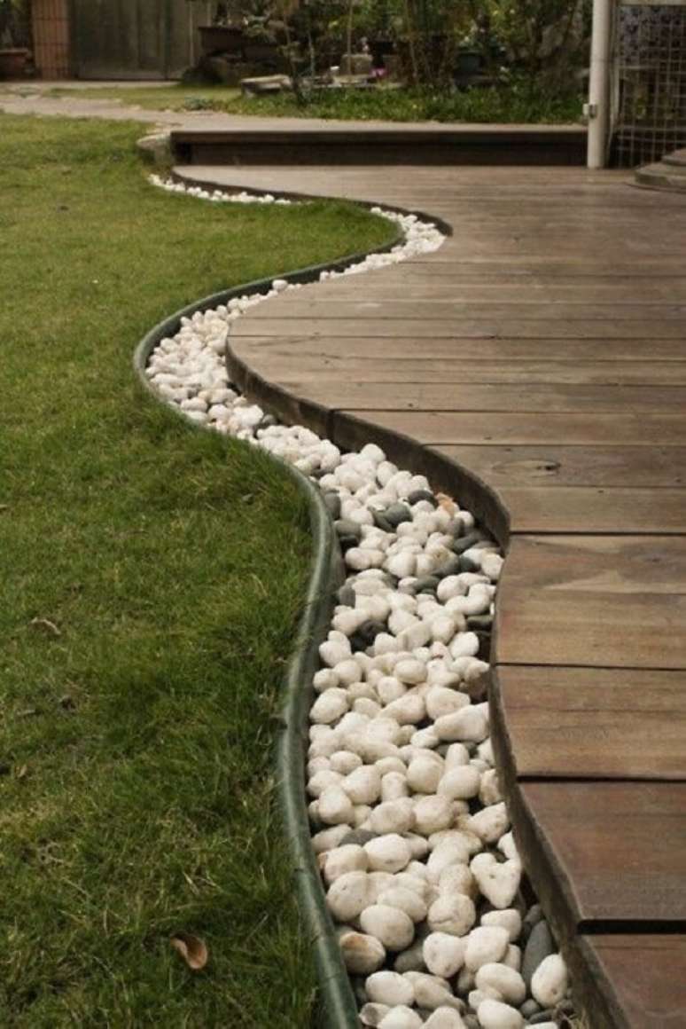 74. As pedras para jardim contornam todo o deck de madeira. Fonte: Pinterest