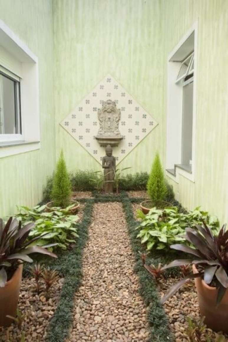 52. Jardim de inverno com ch&atilde;o de pedras e escultura oriental. Projeto de TT Interiores