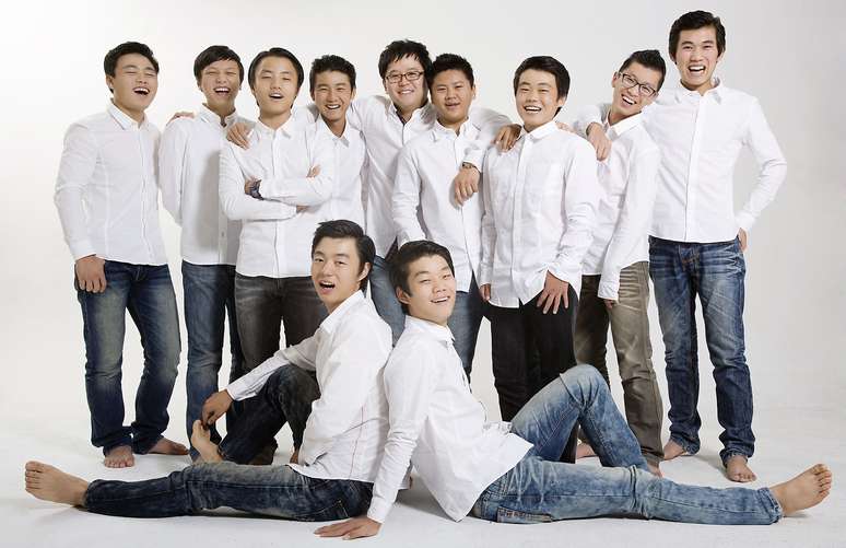 Kim (de p&eacute;, no meio) adotou dez meninos