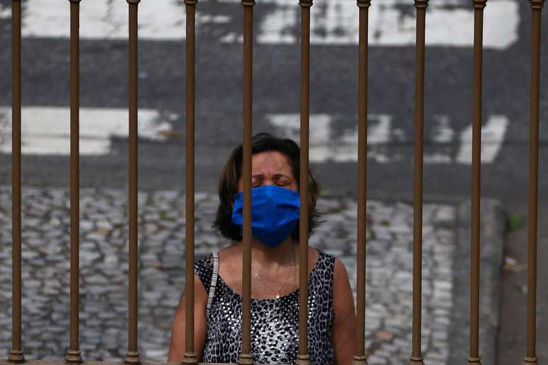 Mulher com m&aacute;scara de prote&ccedil;&atilde;o ora no exterior de igreja do Rio de Janeiro
06/05/2020
REUTERS/Pilar Olivares