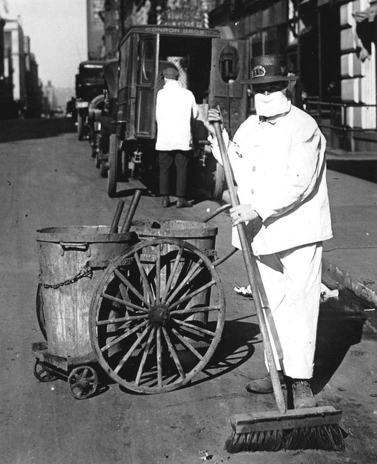 Um funcion&aacute;rio de limpeza p&uacute;blica na cidade de Nova York usa uma m&aacute;scara para ajudar a controlar a propaga&ccedil;&atilde;o da epidemia de gripe, em outubro de 1918 (Foto de PhotoQuest/Getty Images)