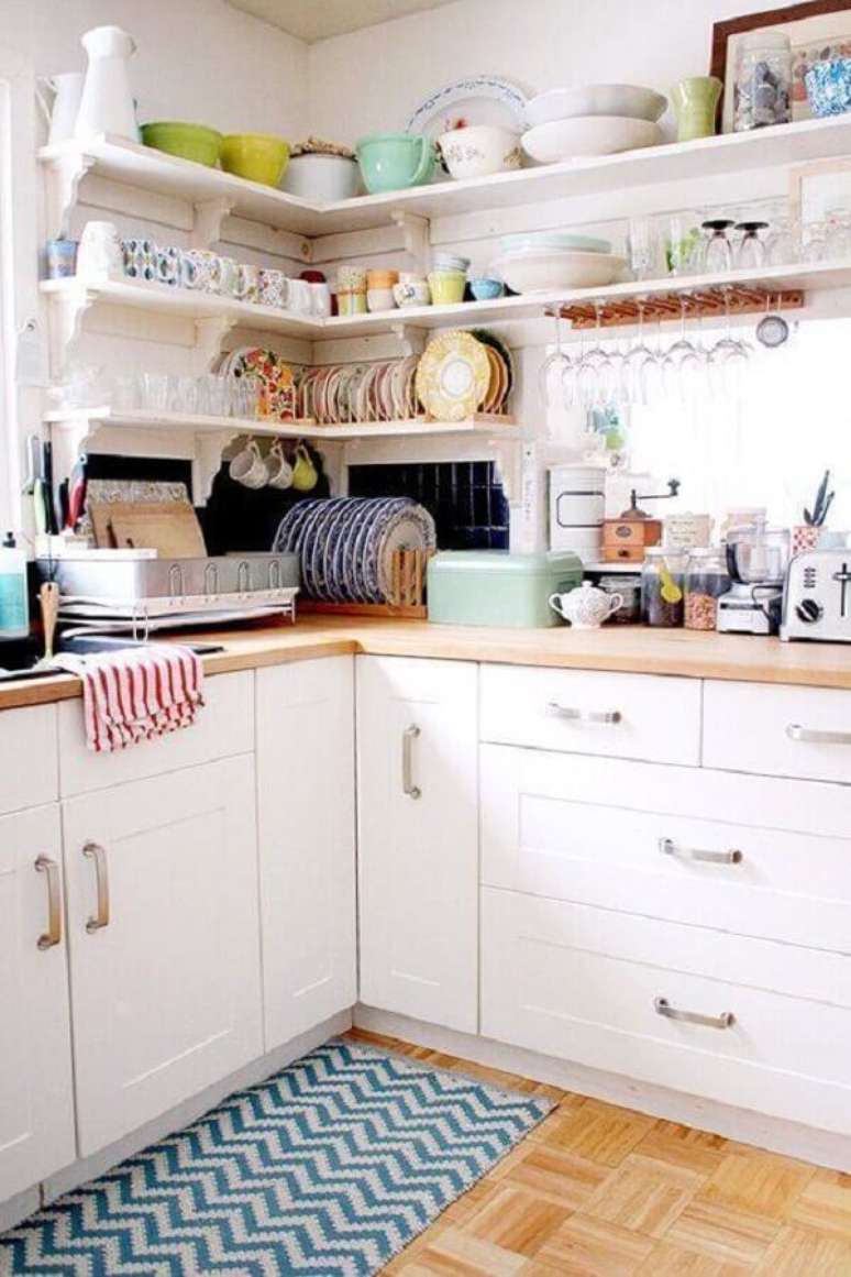79. Decoração com tapete para cozinha planejada com armários brancos e prateleiras de canto – Foto: Behance