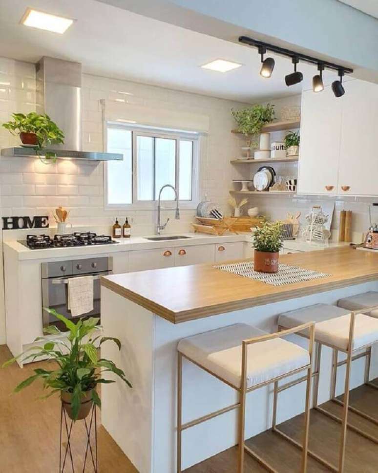 28. Decoração clean para cozinha americana completa toda branca com armários planejados e bancada de madeira – Foto: Pinterest