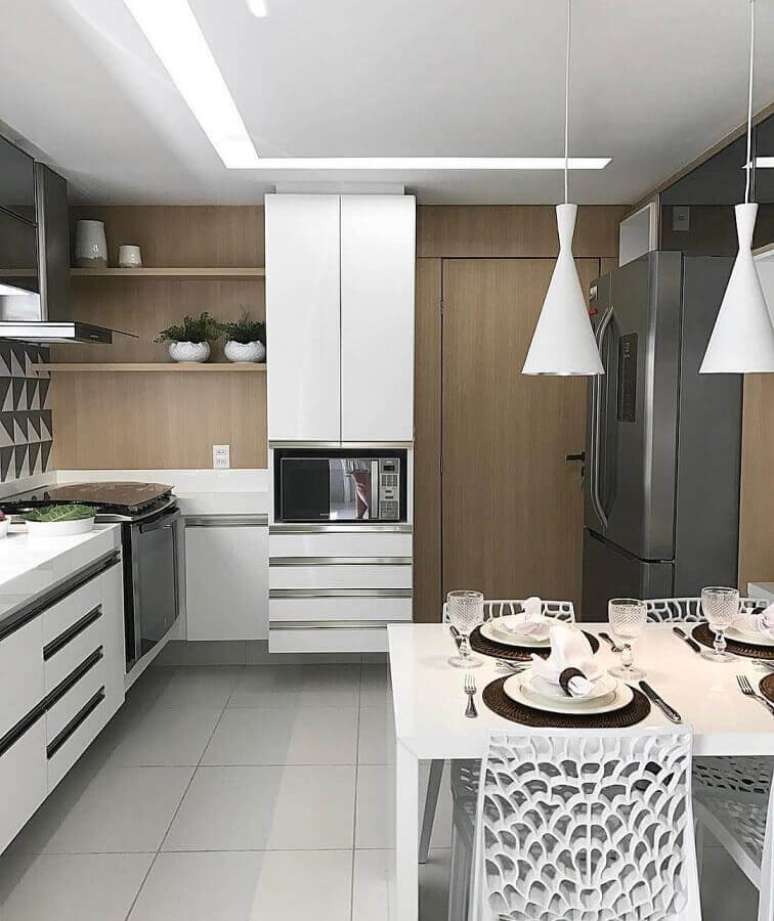 49. Cozinha completa planejada com armários brancos e revestimento de madeira para parede – Foto: Webcomunica