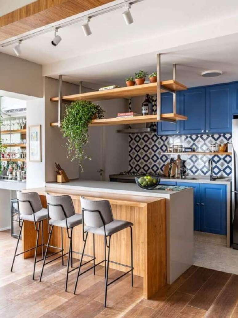 102. Prateleiras de madeira suspensas para decoração de cozinha completa azul e branca com bancada de madeira – Foto: Pinterest