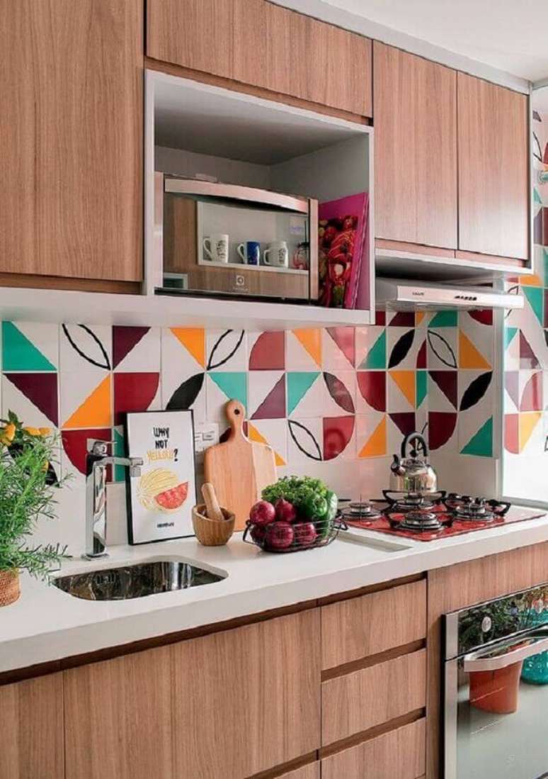 106. Cozinha completa planejada com armários de madeira e revestimentos coloridos – Foto: Minha Casa