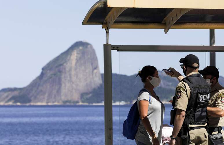 Guardas municipais verificam temperatura de mulher em ponto de ônibus no Rio de Janeiro
11/05/2020
REUTERS/Ricardo Moraes