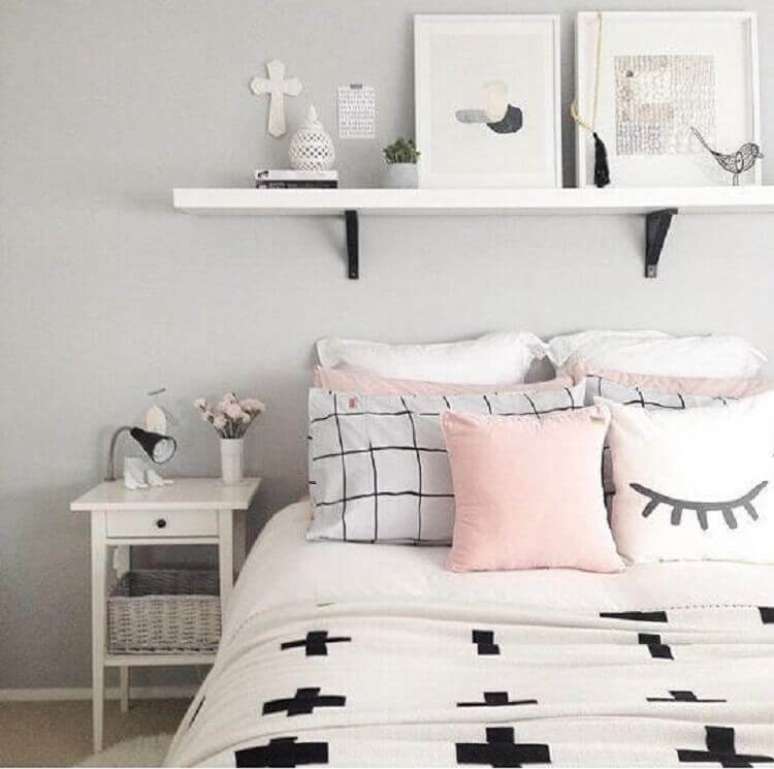 Um quarto com uma cama e uma secretária com um quadro na parede