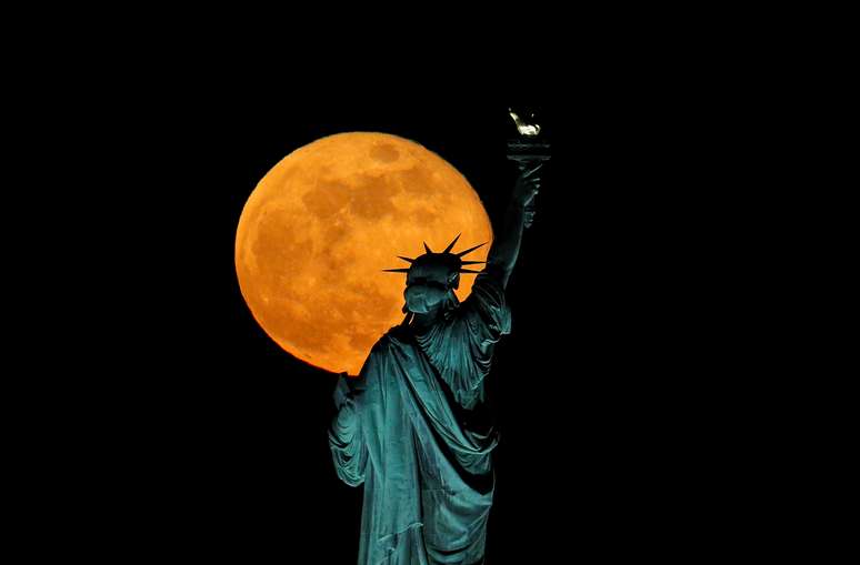 Vista da lua, em fenômeno conhecido como Super Lua, aparece atrás da Estátua da Liberdade, nos EUA.  7/5/2020. REUTERS/Brendan McDermid     