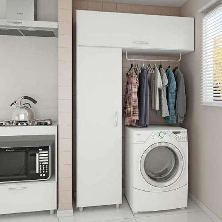 30. Alguns modelos de armário multiuso branco para lavanderia possuem cabideiros – Foto: Pinterest