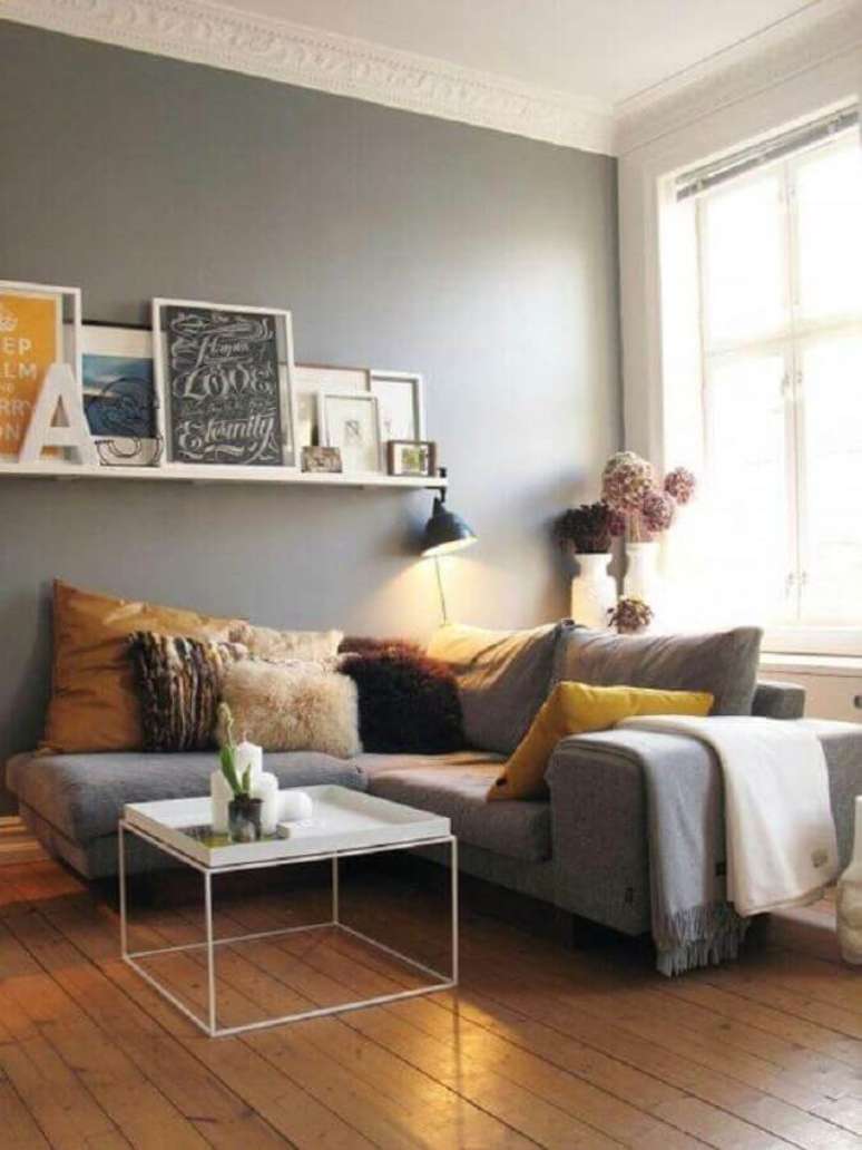 32. Almofadas para sofá de canto cinza em sala com prateleira para quadros – Foto: Archilovers