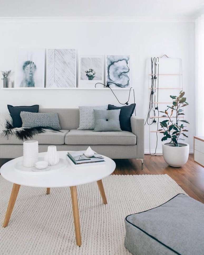 33. Decoração de sala minimalista com sofá cinza e mesa de centro redonda – Foto: Pinterest