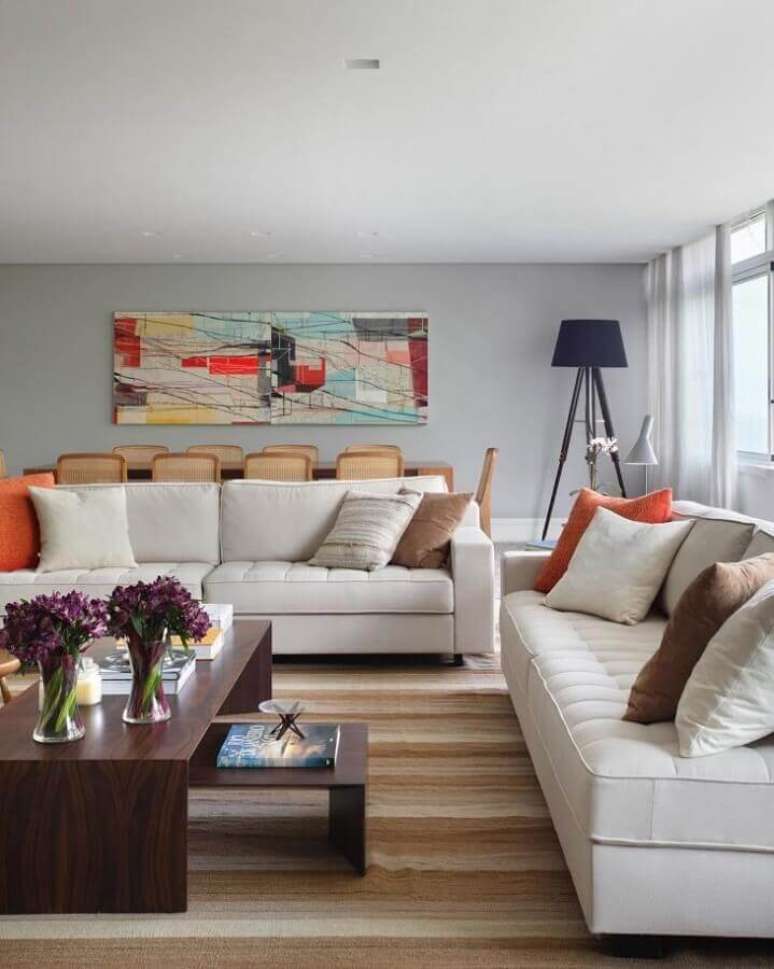 43. Jogo de sofá branco para decoração de sala com tapete listrado e quadro colorido – Foto: Adriana Valle Patrícia Carvalho