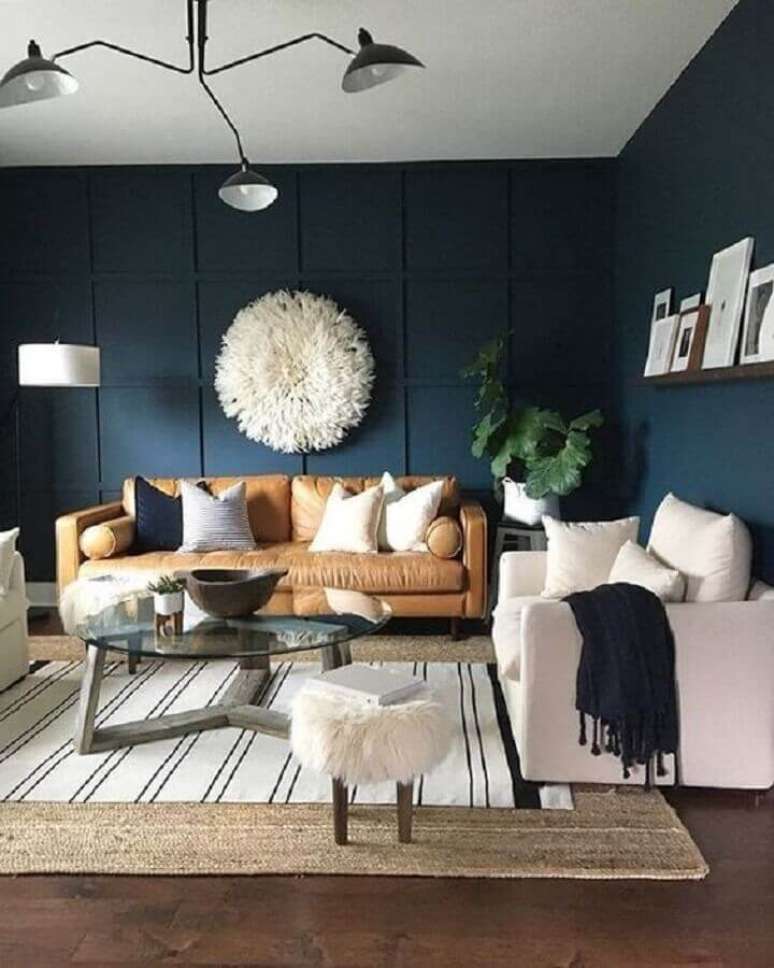 67. Sala decorada com paredes azul marinho e sofá de couro marrom – Foto: Article