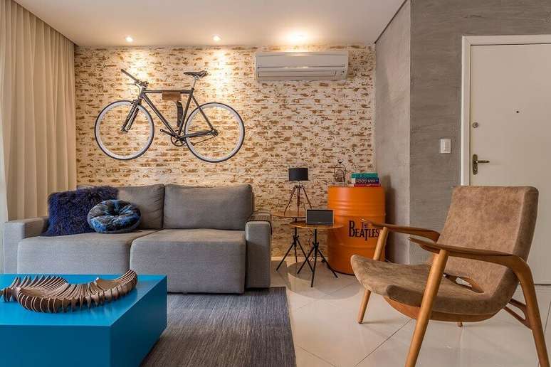 101. Sofá pequeno e cinza para sala decorada com poltrona de madeira e bicicleta na parede – Foto: Flávia Campos Arquitetura