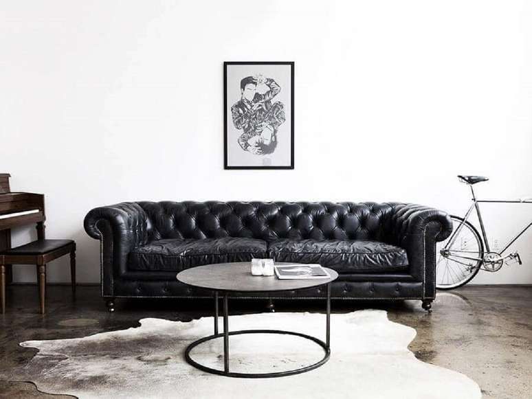 102. Sof&aacute; preto de couro chesterfield para decora&ccedil;&atilde;o de sala com tapete de couro &ndash; Foto: Pinterest
