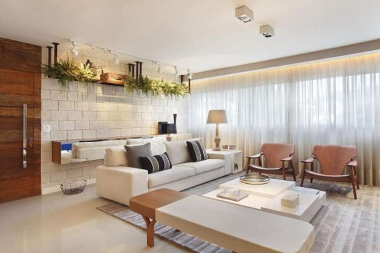 13. Móveis clean para sala de estar com mesa de centro planejada e sofá branco. Projeto por Studio Eloy e Freitas Arquitetura