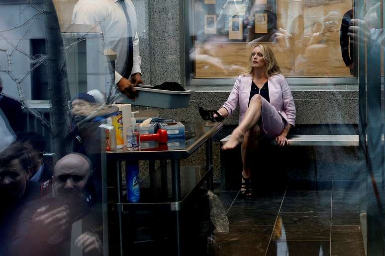 Stephanie Clifford, tamb&eacute;m conhecida como Stormy Daniels, coloca sapato depois de passar pela seguran&ccedil;a ao chegar a tribunal de Manhattan, Nova York
 16/4/2018 REUTERS/Shannon Stapleton    