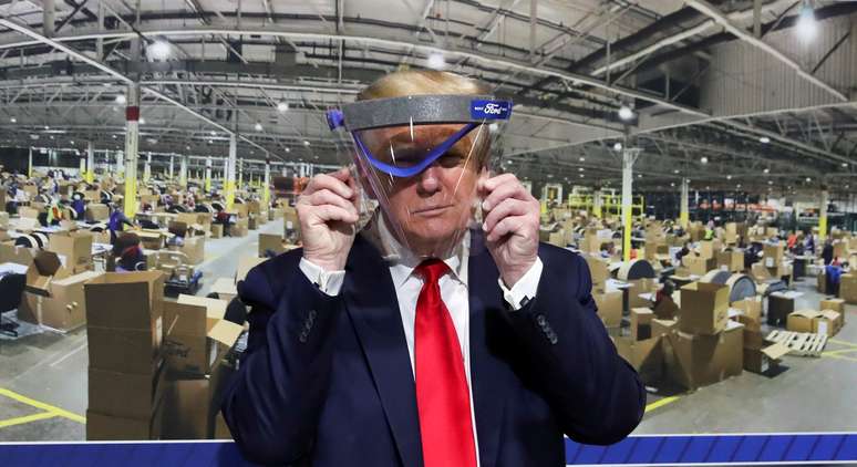 Trump segura escudo de proteção durante visita a fábrica da Ford Rawsonville Components, que fabrica ventiladores, máscaras e outros equipamentos médicos, em Ypsilanti, Michigan
21/5/2020 REUTERS/Leah Millis