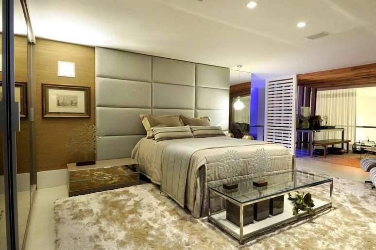 72. Cabeceira casal queen estofada at&eacute; o teto para quarto amplo decorado com tapete felpudo &ndash; Foto: Sergio Palmeira
