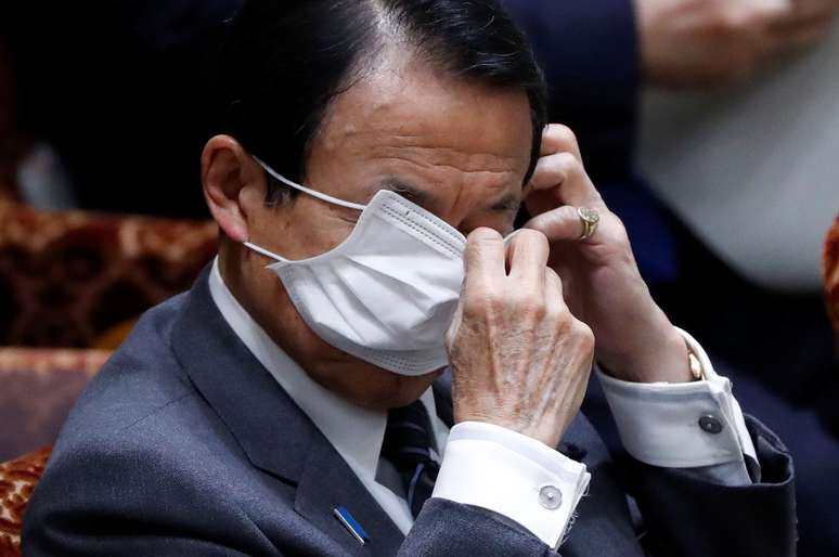 Ministro das Finanças japonês, Taro Aso, ajusta sua máscara durante sessão do Senado em foto de 1 de abril. REUTERS/Issei Kato