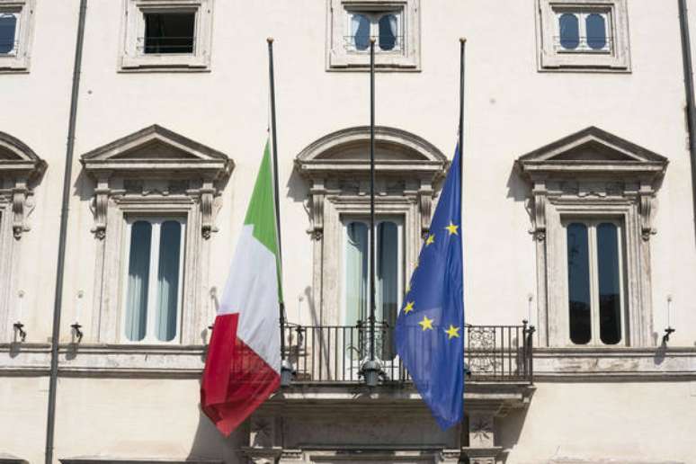 Bandeiras a meio mastro no Palácio Chigi, sede do governo italiano, para homenagear vítimas de pandemia