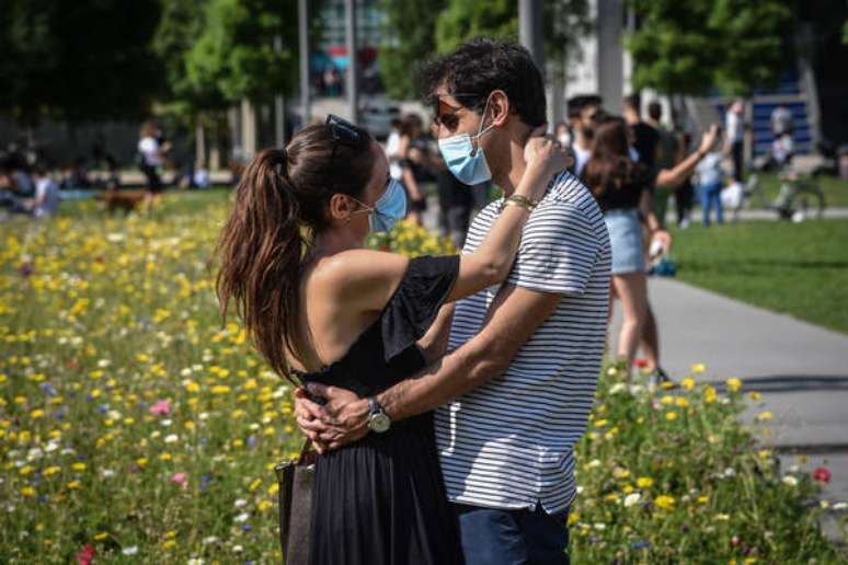 Casal se abraça em parque do Milão neste domingo (24), enquanto contágios por coronavírus na Itália continuam em queda