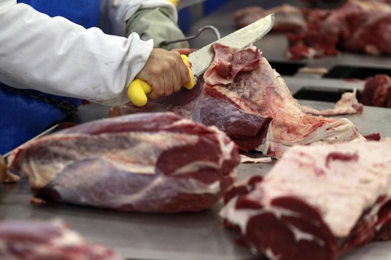 Um trabalhador corta carne de boi. 07/10/2011. REUTERS/Paulo Whitaker.

