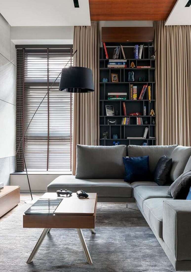 2. Sala de estar moderna decorada com sofá de canto cinza e abajur de chão preto – Foto: Webcomunica
