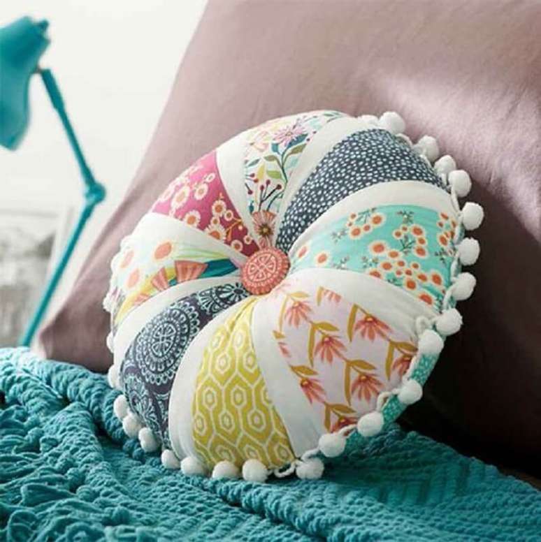 21. Linda almofada redonda feita com retalhos de tecidos coloridos e botão no centro – Foto: Etsy