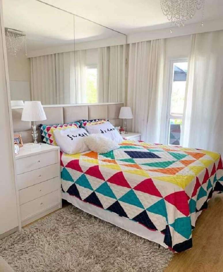 62. A roupa de cama bem colorida fez grande diferença na decoração do quarto de casal bonito todo branco planejado – Foto: Pinterest