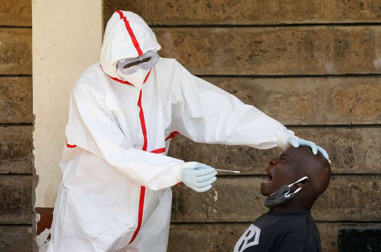 Profissional de saúde com trajes de proteção coleta amostra de paciente para exame de detecção de Covid-19 em Nairóbi
28/05/2020 REUTERS/Baz Ratner