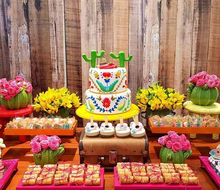 15. Bolo festa mexicana lindo para decoração de mesa bem colorida com arranjos de flores e vários docinhos – Foto: Na Vila Festas