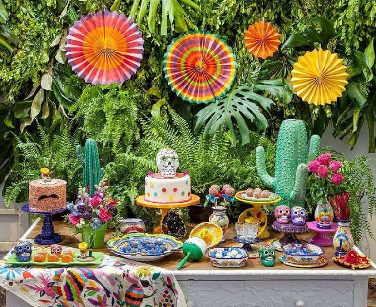 27. Aqui as plantas naturais serviram com painel para a mesa de festa caveira mexicana – Foto: Sweet Tooth Candy Buffets